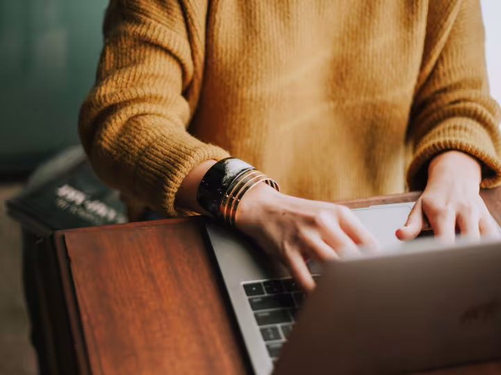 Hands typing on a laptop