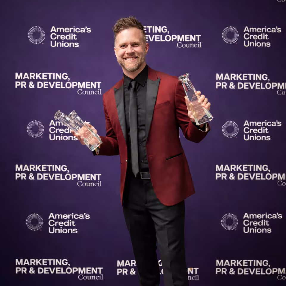 A Simplicity team member holding two Diamond Award trophies at the awards event