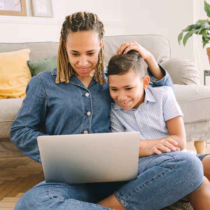 A parent and child looking at a laptop together